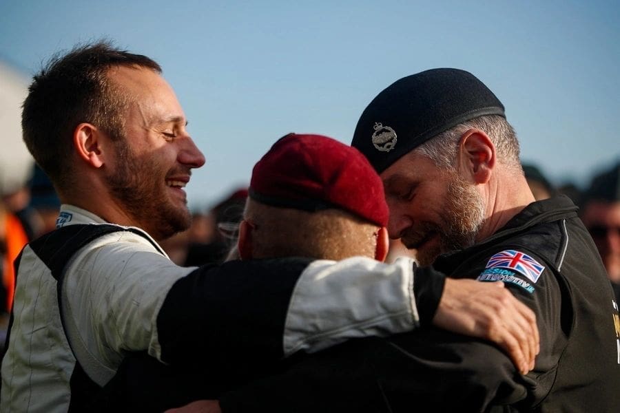 Men in uniform embracing joyfully.