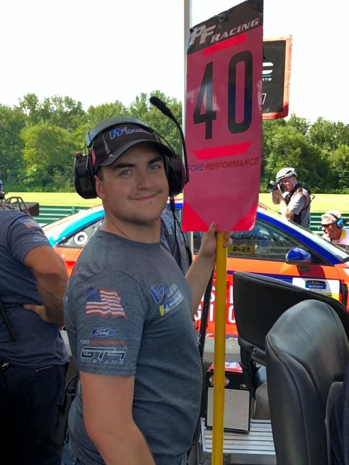 Man holding racing number 40 sign.