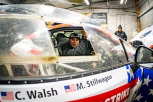 Race car driver in helmet and racing suit.