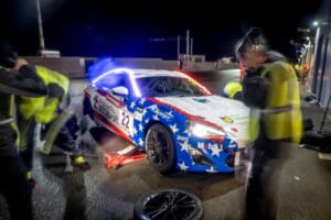 Race car with American flag design being serviced.