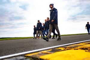 Men in jackets walking on a track.