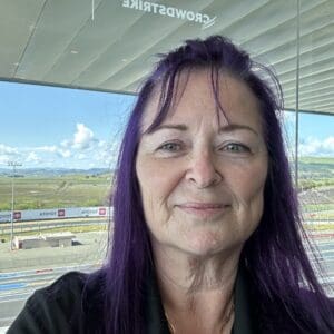 Woman with purple hair at racetrack.