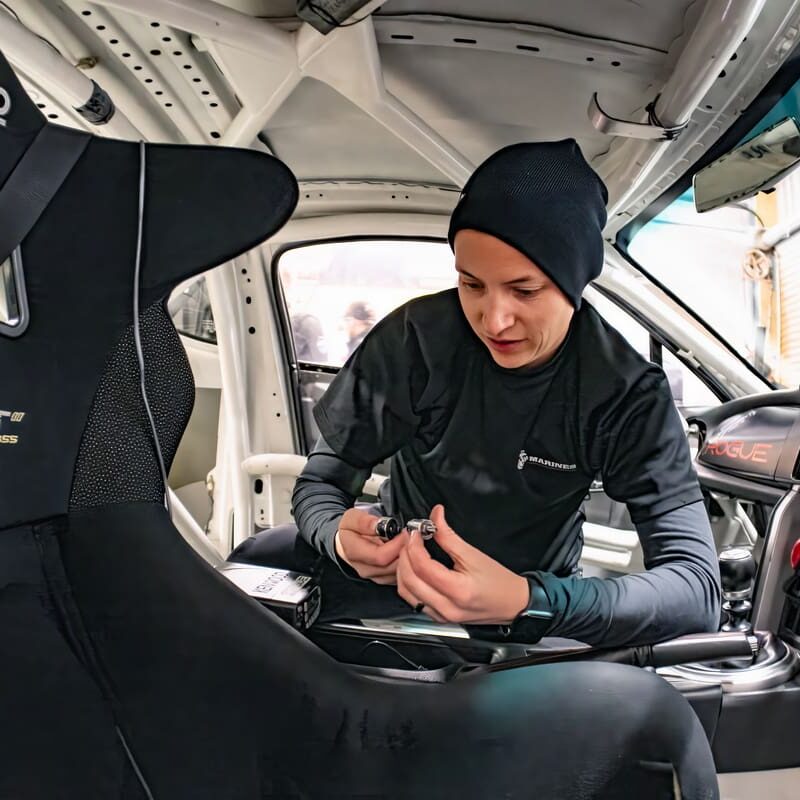 A person working on a race car's interior.